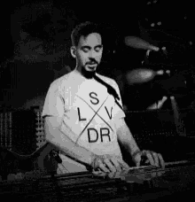 a man is playing a keyboard in front of a microphone .