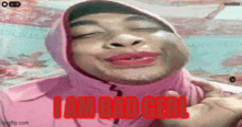a woman is wearing a pink hijab and making a funny face with the words i am bad girl written in red