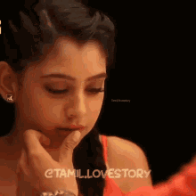 a close up of a person touching a woman 's face with the words tamil lovestory written on the bottom