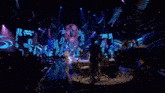 a man in a silver suit is walking on stage
