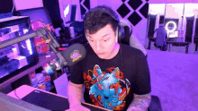 a man wearing headphones and a black t-shirt with a wolf on it