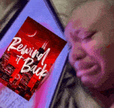 a person is crying while looking at a book called reviving back