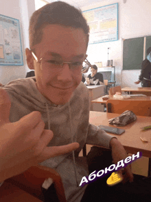 a boy in a classroom with a thumbs up and the word abouden on the bottom