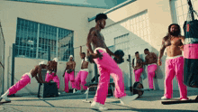 a group of men wearing pink pants are doing exercises