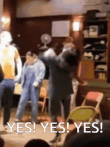 a group of people are dancing in a room and the words yes yes yes are visible