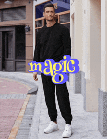 a man wearing a black sweatshirt and sweatpants stands in front of a sign that says magic 8