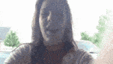 a woman is taking a selfie in front of a car while wearing braces .