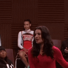 a group of cheerleaders are standing in a room and one of them is wearing a cheerleading uniform that says mhs