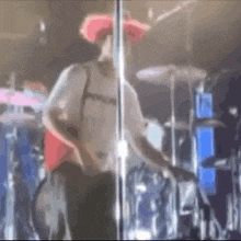 a man wearing a red cowboy hat is standing on a stage playing a guitar .