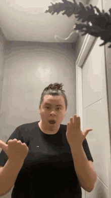 a woman in a black t-shirt is making a funny face