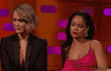 two women are sitting next to each other on a stage .