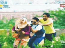 a man in a yellow shirt holds a woman in a pink hijab while two other men push her