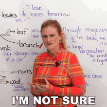 a woman is standing in front of a white board with writing on it including the word leaves