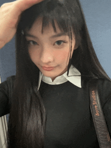 a woman is taking a selfie with a strap that says acne studios on it