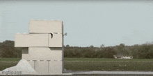 a car is crashing into a stack of concrete blocks .