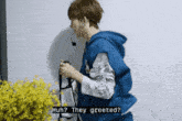 a man in a blue hoodie is holding a bag and says huh they greeted ?