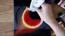 a person is painting with a tube of acrylic paint that says made in animatica