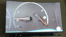 a tv screen shows a speedometer with the numbers 20 and 0 on it