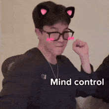 a man wearing glasses and cat ears has the word mind control on his face