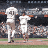 a baseball player wearing a giants jersey walks towards a base