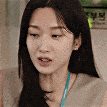 a close up of a woman 's face with a lanyard around her neck