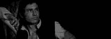 a black and white photo of a man holding a woman 's hand .