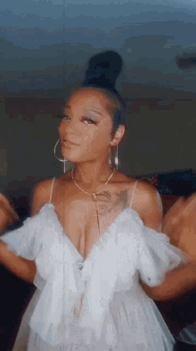 a woman in a white dress has a tattoo on her chest