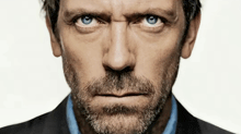 a man with blue eyes and a beard is looking at the camera