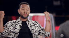 a man in a black and white floral shirt with the word nbc on the bottom