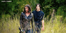 a man and a woman with blood on their faces are walking through tall grass