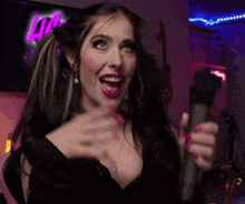 a woman with pigtails is holding a microphone in her hand and smiling .
