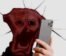 a person is taking a selfie with a phone with a red face in the background