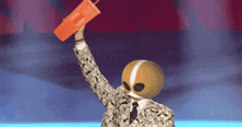 a man in a suit and tie holds up an orange cup with the word coca cola on it