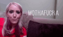 a woman sitting on a couch with mothafucka written on the top