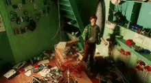 a boy is standing in a messy room with a lot of toys on the floor .