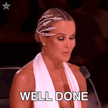 a woman in a white dress is sitting in front of a microphone and the word well done is on the bottom