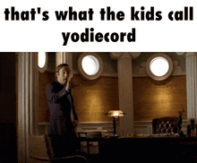 a man in a suit stands in front of a wall that says " that 's what the kids call "