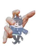 a hand is holding a cartoon character with a cat ear and a blue hoodie