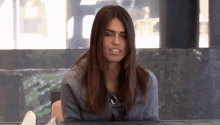 a woman sitting at a table with her eyes closed and her mouth open