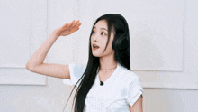 a woman wearing headphones and a white shirt is waving her hand