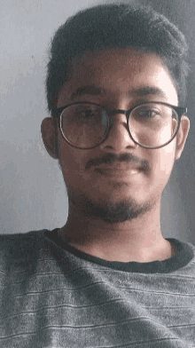 a man with glasses and a beard looks down