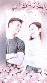 a man and a woman are standing next to each other with their arms crossed surrounded by pink flowers