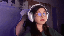 a woman wearing glasses and headphones is making a face