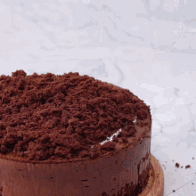 a chocolate cake with crumbs on top and a gold spoon