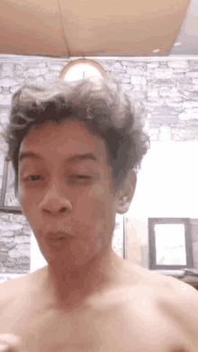 a shirtless man is making a funny face in front of a clock