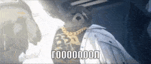 a man wearing a white jacket and gold chains is standing in a dark room .