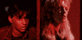 a man and a woman standing next to each other in a red light