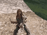 a person playing a guitar on a rocky cliff