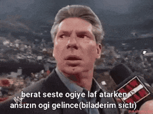 a man in a suit is talking into a microphone with the words berat seste ogiye