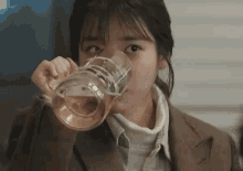 a woman is drinking a glass of beer from a glass .